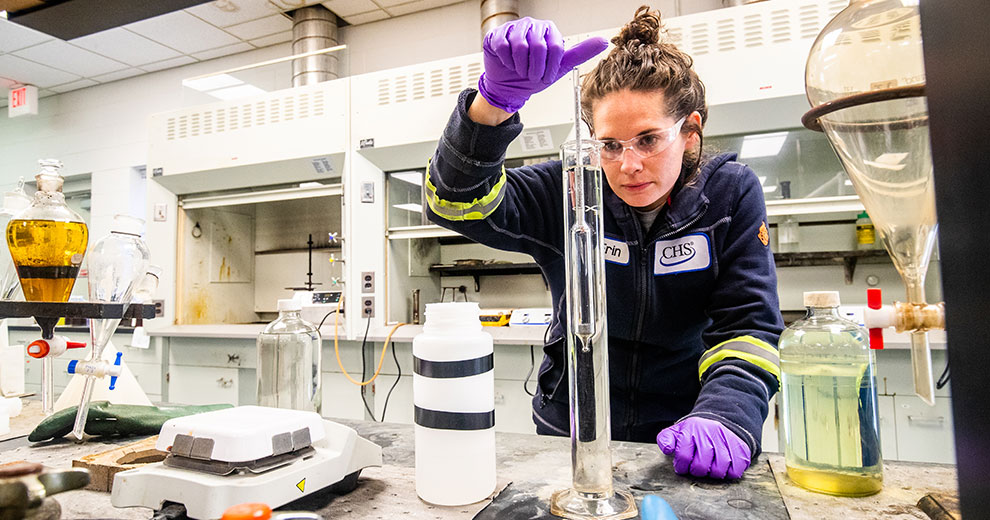Woman wearing safety gear working in a chemistry lab