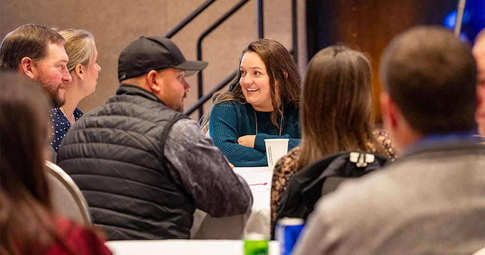 A group of men and women sitting around a table