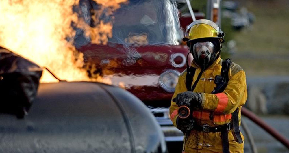 Firefighters spraying a burning propane tank