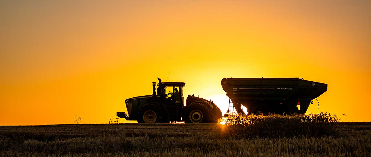 tractor with trailer in sunset
