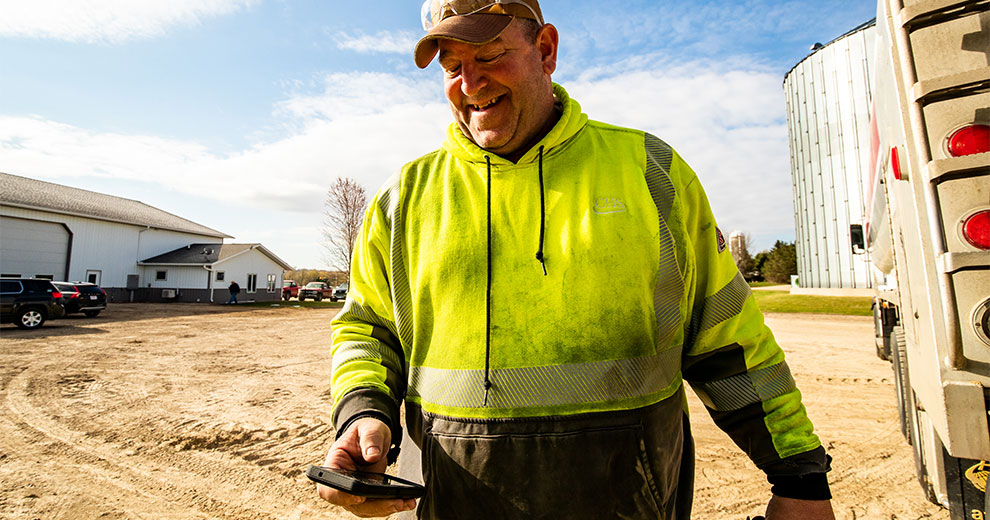 Driver wearing safety gear looking at cell phone