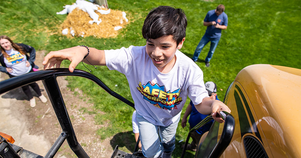 FFA student climbing a tractor