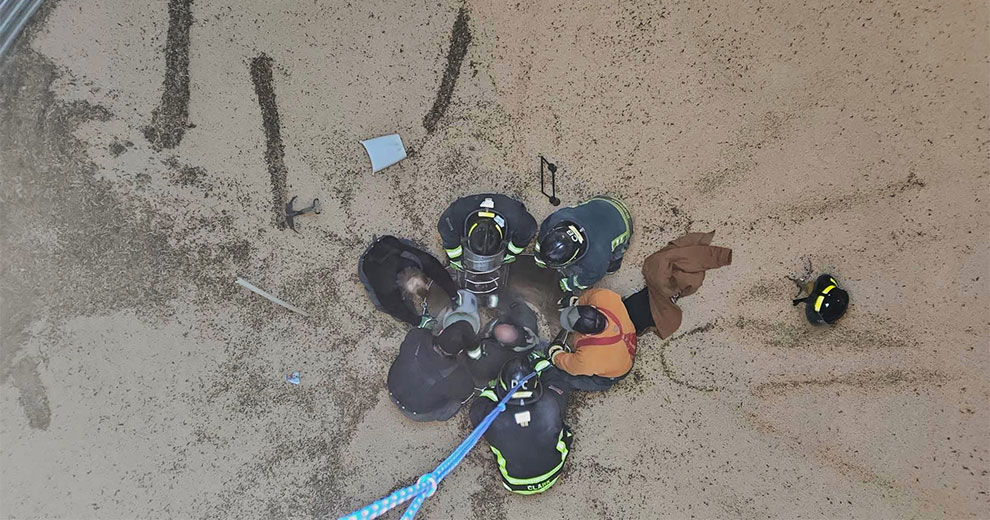 Firefighters rescuing a man from a grain engulfment