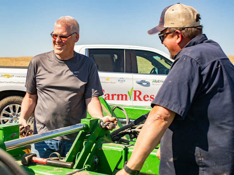 A man smiling standing by a planter