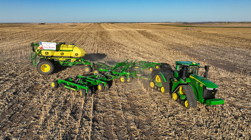A large green tractor and planter in a field