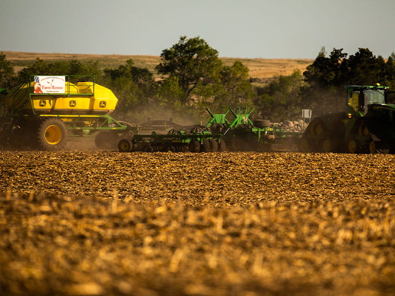 A tractor and planter in a field 