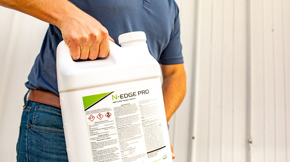 Man holding a jug of farm chemicals.