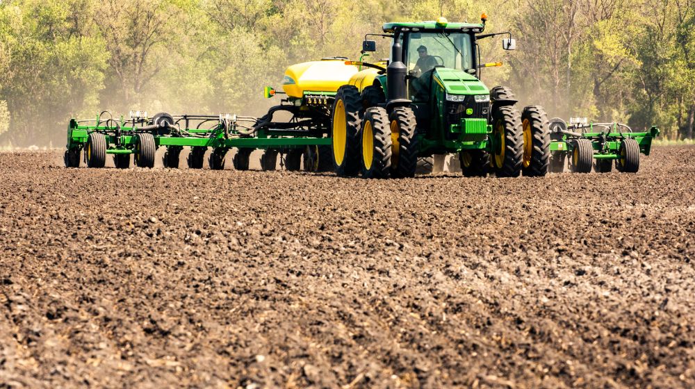 Tractor pulling a planter and fertilizer unit.
